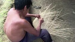 Over-the-shoulder shot of middle-aged Kichwa Indian male weaving a natural plant-based basket in the autonomous indigenous region of Sarayaku in the Ecuadorian Amazon Stock Footage