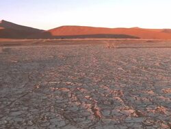 Cracked earth and dune, Sossusvlei, Namib-Naukluft, Namibia Stock Footage
