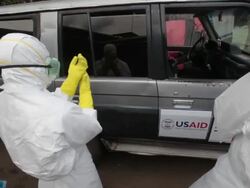 Ebola body collection team in Monrovia Liberia puts on PPE hazmat suits Stock Footage