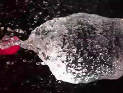 High speed Pink water-filled balloon bursts Stock Footage