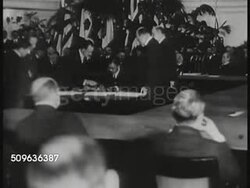 1921/1922: INTERNATIONAL CONFERENCE ON NAVAL LIMITATION: HA WS INT Building w/ people seated at large square table & in gallery BG. Unidentified Japanese male signing paper, British Prime Minister Lord Balfour signing, CU signatures on treaty w/ seals Instructional Video