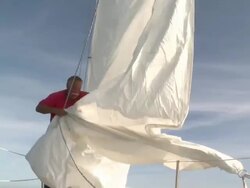MS Pensioner ties down sail on his sailboat in sun on calm day / Wismar, Mecklenburg-Vorpommern, Germany Stock Footage