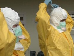 TS as two health care workers remove PPE head covering Stock Footage
