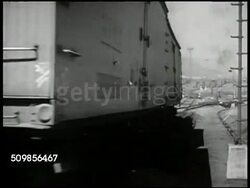 1947: U.S. FREIGHT YARD: CU Trainman throwing switch on tracks. MS Man uncoupling moving cars. MS Freight moving on tracks. MS Man in control tower. CU Turning switch. MS Device for railroad humping operation. CU Train moving over tracking device. USA Instructional Video