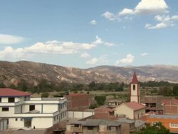L-R Pan of mountains skirting Cochabamba, Bolivia, with residential areas and church steeple in view. Stock Footage