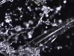 CU SLO MO Shot of two sources of water from left and right crash together mid frame against black / United Kingdom Stock Footage
