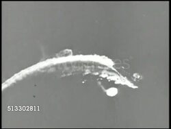 1942: BATTLE OF MIDWAY: WS U.S. Navy Douglas SBD Dauntless dive bombers flying in formation, diving, smoke in sky, explosion in water by Imperial Japanese battleships, vessels. VS Japanese firing anti-aircraft artillery, plane flying overhead. WWII Instructional Video