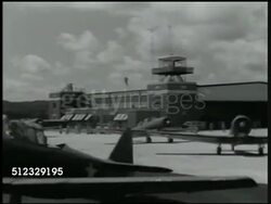 1942: U.S. MARINE CORPS: AIR SQUADRON: MS Two Naval Air Force pilots (gunner) in cockpit, moving. WS Fighter airplanes (variation of Curtiss P-36 Hawk, unconfirmed) taxiing on field. VS Pilots in gear looking at plans, map at table, talking, tent BG. Instructional Video