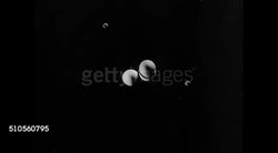 1946: ANIMATED GRAPHICS: Nucleus of atom (C) w/ electrons in orbit around nucleus. LAB: Laboratory Lightning Electric current between two conductors wires. 'Lightning' electricity running up conductor wires. 'Lightning' flowing up. Instructional Video