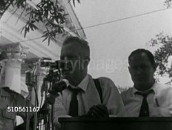 1948: UNCLE EARL: Politician Earl Kemp Long (1895-1960) sitting at outdoor table behind microphones, SOT Partial speech ...making no deals...no trades...can help the poor man, the middle man and the rich man-if he'll behave himself. FREEZE FRAME. Instructional Video