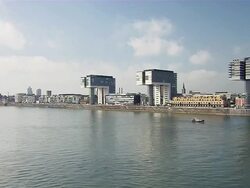 WS Small boat moving in front of three Cranehouses with buildings in city / Cologne, North Rhine-Westphalia, Germany Stock Footage
