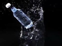 MS SLO MO Shot of Plastic bottle of water falling and splashing against black background / Calvados, Normandy, france Stock Footage