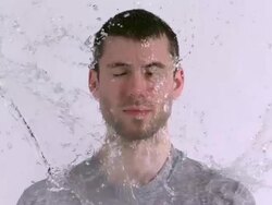 CU SLO MO Shot of Caucasian male against white canvas and water being thrown on him / Studio, New York, United States Stock Footage