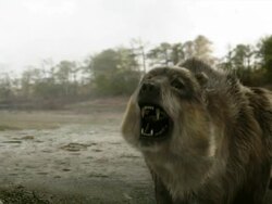 Medium Close Up pan-left push-in - A creature prowls across a muddy field near a forest in a computer-generated animation. / Los Angeles, California, USA Stock Footage