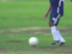 A man playing soccer on a grassy field. - Slow Motion - filmed at 240 fps Stock Footage