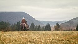 Two people riding horses across meadow Stock Footage