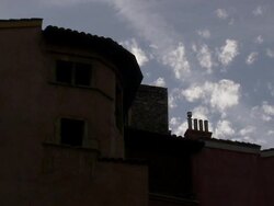Clouds float above ancient ceramic roof tiles and chimneys. Stock Footage