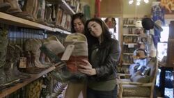 Excited young women look at cowboy boots and take smartphone photo in Western store Stock Footage