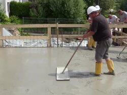 MS Shot of workmen smoothing and leveling concrete at house construction, building site / Hermeskeil, Rhineland Palatinate, Germany Stock Footage
