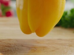 CU R /F Shot of Two halves of organic yellow bell pepper fall to cutting board / Los Angeles, California United States Stock Footage