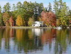 WS View of beautiful fall scene of Lake Pennasseewassee with summer homes and fall colors in leaf peeping October with reflections in water in Northern New England / Norway, Maine, United States Stock Footage