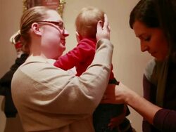 MS Female chiropractor adjusts babies back as mother holds baby / Toronto, Ontario, Canada Stock Footage