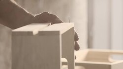 Carpenter hammering nail, creating wooden crate Stock Footage