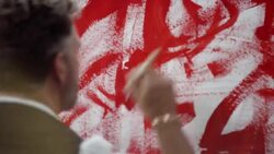 Artist painting with red color on canvas Stock Footage