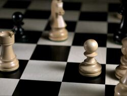 High speed white chess rook falling, some figures standing around, tracking shot Stock Footage