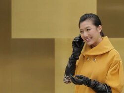 MS Young woman in yellow coat using mobile phone and smiling / China Stock Footage
