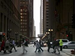 MS Shot of axis with pedestrian crossing with buses, train and cars moving at subway and yellow policeman standing / Chicago, Illinois, United States Stock Footage