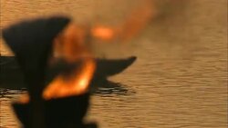 Boat passengers snap photos as they glide down the Ganges and a Diwali flame burns on shore. Stock Footage