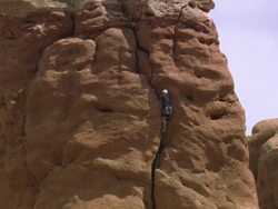 ZO Rock climber scaling up large rock formation at Arches National Park / Utah, United States Stock Footage