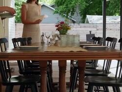 MS two sisters setting table for dinner on front porch of home Stock Footage