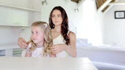 Bridesmaid fixing flower girlï¿½s hair before wedding Stock Footage
