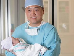 MS Portrait of Doctor in Surgical Scrubs Holding Newborn Baby in Hospital / Richmond, Virginia, USA Stock Footage