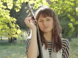 Young woman posing in park, holding guitar, smiling, flirting outdoors. Stock Footage