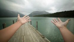 Woman's arms stretch towards mountain lake. POV Stock Footage