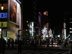 MS Shot of Busy city scene with pedestrians and traffic at night with street lights and neon retail signs in Ginza / Tokyo, Japan Stock Footage