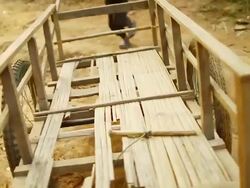 MS TS R/F SLO MO Shot of boy pushing small wooden cart on irregular ground / Mountain village near Muang Ngoi, Luang Prabang, Laos Stock Footage
