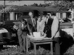 1950s: FARM EQUIPMENT: VS Various males looking over farm machinery on field, looking over plans on table outdoors, males talking (SOT), '...we have the right answer to hay...,' plans for grass silos. Agriculture, farming, farmland Instructional Video