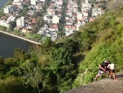 WS Mountain climber climbing sugar loaf urca neighborhood / Rio de Janeiro, Brazil Stock Footage