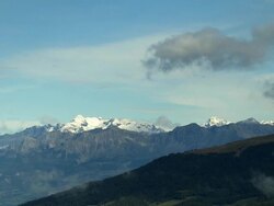 AERIAL Tree-covered mountainside with snowy peaks in background/ Alpes-Maritimes, France Stock Footage
