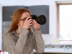 Young woman using DSLR, home interior. Stock Footage