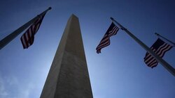 American flags flutter next to the Washington Monument. Stock Footage