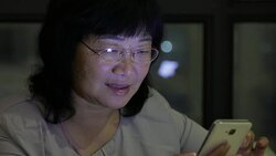 Old woman using mobile phone at home Stock Footage