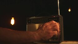 CU of man's arm adjusting old radio Stock Footage