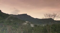 Fog rolls over wooded mountains. Stock Footage