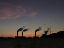 Smokestacks silhouetted against dusk sky Stock Footage