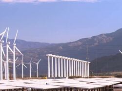 PAN across solar photovoltaic power plant near wind farm and freeway traffic  / Palm Springs, California, USA Stock Footage